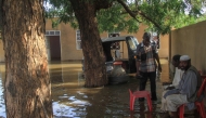 Residents sit in a pool of water due to the flooding of the Nile river in the Sudanese village of Wad Ramli north of Khartoum on October 1, 2025. (Photo by Ebrahim Hamid / AFP)
