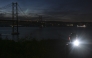 This photograph shows the 25th April bridge over the Tagus river with the lights off following a massive power cut affecting the entire Iberian peninsula and the south of France, in Lisbon on April 28, 2025. Photo by Patricia DE MELO MOREIRA / AFP.

