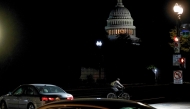 The US Capitol looms in the distance as a man rides his bike up Independence Avenue towards Capitol Hill, on the second day of the US government shutdown in Washington, DC, on October 2, 2025. Photo by Brendan Smialowski / AFP