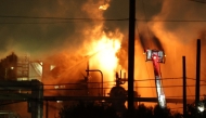 A firefighting crew works to contain a fire at the Fire Chevron Products Company El Segundo Refinery in the early morning hours on October 3, 2025, in El Segundo, California, following an explosion at the oil refinery that occurred late on October 2. Photo by Patrick T. Fallon / AFP