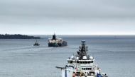 This handout picture taken and released by The Finnish Border Guard on March 2, 2025 shows the Border Guard ship Turva (front) escorting Cook Islands registered oil tanker Eagle S out to sea near Porvoo (Borga), Finland. Photo by Handout / various sources / AFP

