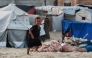 A displaced Palestinian child runs amid tents used as temporary shelter, in Deir el-Balah in the central Gaza Strip, on October 5, 2025. (Photo by Bashar Taleb / AFP)