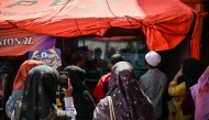 Relatives of missing students watch a live broadcast of the rescue operation near the collapsed Al Khoziny Islamic boarding school in Sidoarjo, East Java, on October 6, 2025, as recovery efforts continue. Photo by JUNI KRISWANTO / AFP