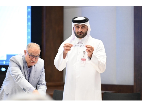 An official picks a team during the official draw ceremony.