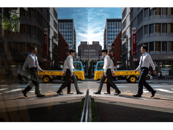 Pedestrians are seen reflected in glass as they walk in the Ginza district of Tokyo on October 8, 2025. (Photo by Philip FONG / AFP)