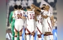 Qatar players gather on the pitch during the match against Oman.