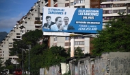 A billboard accusing opposition leaders (L-R) Leopoldo Lopez, Maria Corina Machado and Juan Guaido, for the US sanctions imposed on the country, is seen in Caracas on October 10, 2025, after Machado was awarded the Nobel Peace Prize. (Photo by Federico Parra / AFP)
