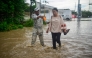 A member of the National Guard helps evacuate a woman through a flooded street following heavy rains in Poza Rica, Veracruz state, Mexico, on October 10, 2025. (Photo by Marco Antonio Perez / AFP)
