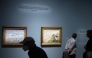 People view paintings by French artist Claude Monet on display at the 