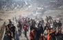 Palestinians walk along the “Netzarim corridor” in central Gaza yesterday to return to their homes. (AFP)