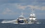 This handout photo taken and released on October 12, 2025 by the Philippine Coast Guard shows a China Coast Guard ship (R) deploying water cannon as a Philippine Bureau of Fisheries vessel (L) is seen alongside during an incident near Thitu island in disputed waters of the South China Sea. Photo by Handout / Philippine Coast Guard (PCG) / AFP