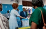 Paul Biya, President of Cameroon and presidential candidate for the Cameroon People's Democratic Movement (CPDM), watches as Cameroon First Lady Chantal Biya casts her ballot at a polling station in Yaounde on October 12, 2025 during Cameroon's presidential election. (Photo by Daniel Beloumou Olomo / AFP)