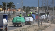 Trucks carrying aid provided by the World Food Programme (WFP) drive on a road in Deir el-Balah on October 17, 2025. (Photo by Bashar Taleb / AFP)