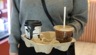 A customer holds a tray with coffee drinks in New York City on October 16, 2025. (Photo by Angela Weiss / AFP)