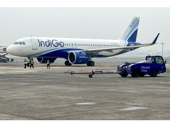 (Files) Ground staff walk past an Indigo airlines aircraft taxiing in the apron at the Netaji Subhash Chandra Bose International airport in Kolkata on February 1, 2024. (Photo by Indranil Mukherjee / AFP)