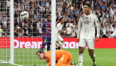 Real Madrid's English midfielder #05 Jude Bellingham scores his ream's second goal during the Spanish league football match between Real Madrid CF and FC Barcelona at Santiago Bernabeu Stadium in Madrid on October 26 , 2025. (Photo by Oscar DEL POZO / AFP)