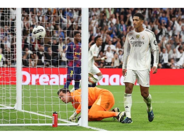 Real Madrid's English midfielder #05 Jude Bellingham scores his ream's second goal during the Spanish league football match between Real Madrid CF and FC Barcelona at Santiago Bernabeu Stadium in Madrid on October 26 , 2025. (Photo by Oscar DEL POZO / AFP)
