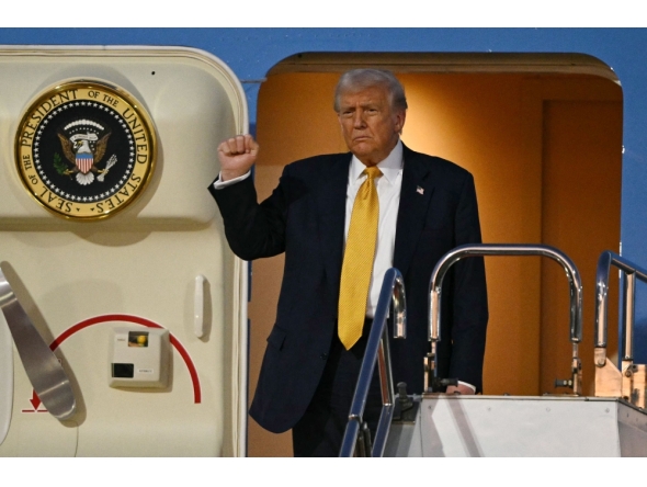 US President Donald Trump gestures as he prepares to alight from Air Force One upon arrival at Haneda Airport in Tokyo on October 27, 2025. (Photo by Philip Fong / AFP)
 