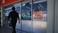 A 'We Accept Food Stamps' sign hangs in the window of a grocery store on October 31, 2025 in Miami, Florida. (Photo by Joe Raedle / Getty Images via AFP)