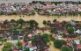 (Files) This aerial picture shows floodwaters inundating streets and buildings following heavy rains in Hoi An on October 30, 2025. (Photo by NHAC NGUYEN / AFP)