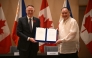 Philippines' Secretary of National Defence Gilberto Teodoro (R) with Canadian Minister of Defence David McGuinty hold their signed documents of the visiting forces agreement after their bilateral meeting in Manila on November 2, 2025. (Photo by Ted ALJIBE / AFP)