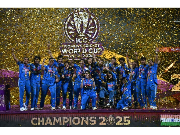 India's players celebrate with the trophy after winning the ICC Women's Cricket World Cup 2025 one-day international (ODI) final match between India and South Africa at the DY Patil Stadium in Navi Mumbai on November 3, 2025. (Photo by Punit PARANJPE / AFP)