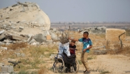 Displaced Palestinian children collect branches and twigs to use for cooking amid fuel shortage in the village of Juhr al-Dik, east of the Bureij refugee camp in the central Gaza Strip, on November 3, 2025. (Photo by Eyad Baba / AFP)
