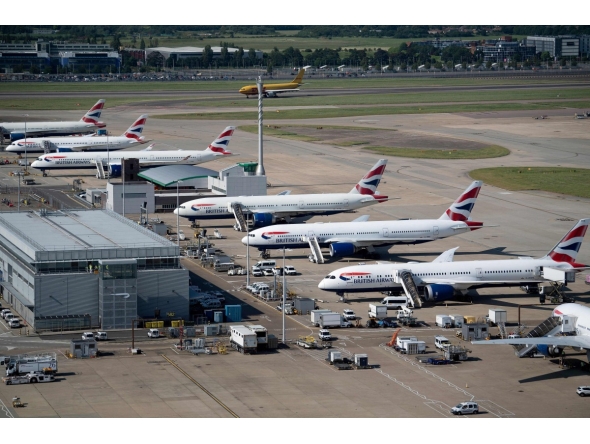 British Airways jets are seen parked on the tarmac at Heathrow Airport on June 13, 2021, in west London. Photo by Brendan Smialowski / AFP