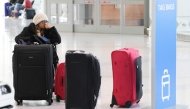 A traveler waits with her luggage at Newark Liberty International Airport in Newark, New Jersey, on November 7, 2025. (Photo by Timothy A. Clary / AFP)