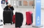 A traveler waits with her luggage at Newark Liberty International Airport in Newark, New Jersey, on November 7, 2025. (Photo by Timothy A. Clary / AFP)
