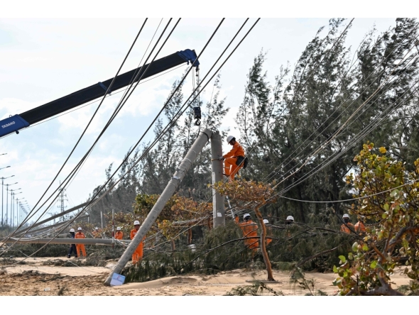 An electricity crew works on downed power lines to restore services in the aftermath of Typhoon Kalmaegi in Gia Lai province, central Vietnam on November 7, 2025. (Photo by Nhac Nguyen / AFP)