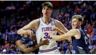 North Florida guard Dante Oliver, left, and North Florida forward Nestor Dyachok, right, guard against Florida center Olivier Rioux, center, in Gainesville, Florida. Chris Watkins/AP Photo