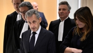 Former French president Nicolas Sarkozy speaks to the press flanked by his wife Carla Bruni and French lawyer Jean-Michel Darrois after the verdict in his trial at the Tribunal de Paris courthouse in Paris, on September 25, 2025. Photo by Julien De Rosa / AFP