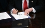US President Donald Trump signs the bill package to re-open the federal government in the Oval Office of the White House in Washington, DC, on November 12, 2025. (Photo by Brendan Smialowski / AFP)