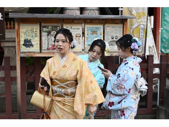 Chinese tourists adjust their kimono as they visit the Sensoji Temple in the Asakusa district of Tokyo on November 15, 2025. (Photo by Greg Baker / AFP)