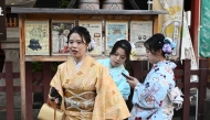 Chinese tourists adjust their kimono as they visit the Sensoji Temple in the Asakusa district of Tokyo on November 15, 2025. (Photo by Greg Baker / AFP)