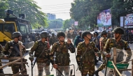 Security personnel stand guard as demonstrators attempt to demolish the residence of Sheikh Mujibur Rahman in Dhaka on November 17, 2025. (Photo by Munir Uz Zaman / AFP)