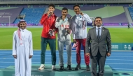 Qatar's Abubaker Haydar (right) celebrates with the gold and silver medal winners on the podium.