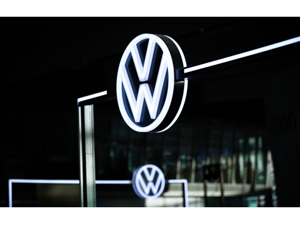 The illuminated VW Logo is pictured in the customer centre at the headquarters of German carmaker Volkswagen (VW) in Wolfsburg, central Germany, on November 21, 2025. (Photo by Ronny Hartmann / AFP)
