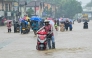 People wade through a flooded road after heavy rainfall in Kaduwela on the outskirts of Colombo on November 28, 2025. (Photo by Ishara S. KODIKARA / AFP)
