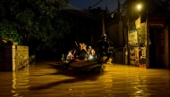 People ride on a boat belonging to Sri Lanka's army at a flooded street after heavy rainfall in Wellampitiya on the outskirts of Colombo on November 30, 2025. (Photo by Ishara S. KODIKARA / AFP)
