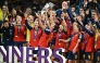 Spain’s players celebrate with the trophy. 