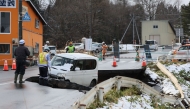 A vehicle is seen on a collapsed road in Tohoku town in Aomori Prefecture on December 9, 2025, following a 7.5 magnitude earthquake off northern Japan. (Photo by JIJI Press / AFP)