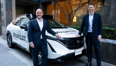 Nissan Motor CEO Ivan Espinosa (L) and Wayve Technologies CEO Alex Kendall (R) pose with a vehicle equipped with the ProPILOT next-generation driver assistance technology system after their signing ceremony in Tokyo on December 10, 2025. (Photo by Kazuhiro Nogi/ AFP)