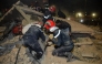 Emergency personnel search for victims in the rubble of two collapsed buildings in the Al Massira area of Fes late on December 9, 2025. (Photo by Ahmed Alaoui Mrani / AFP)
