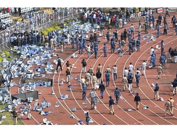 Security personnel try to control the crowd as Inter Miami's Argentine forward #10 Lionel Messi departs from the Salt Lake Stadium in Kolkata on December 13, 2025. (Photo by Dibyangshu Sarkar / AFP)
