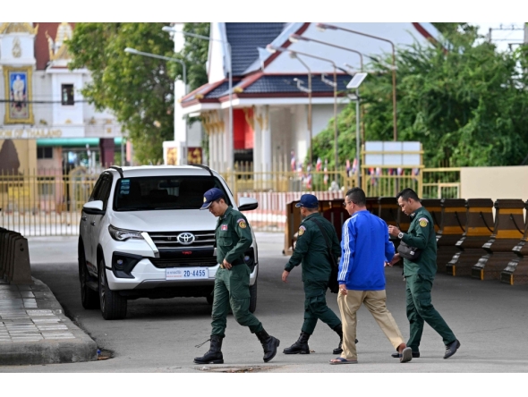 Cambodian police officials walk at the closed Poipet International border checkpoint between Cambodia and Thailand in Poipet, Banteay Meanchey province on December 12, 2025, amid clashes along the Cambodia-Thailand border. (Photo by Tang Chhin Sothy / AFP)