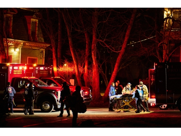First responders with the Providence Fire Department maneuver an empty stretcher near the Barus & Holley building, home to the engineering and physics departments and the site of a mass shooting, at Brown University campus in Providence, Rhode Island, on December 13, 2025. The gunman killed two people and critically wounded eight others, authorities said, urging people in the area to remain in lockdown as the attacker was still at large. (Photo by Bing Guan / AFP)