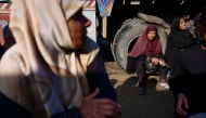 Displaced Palestinians wait to receive donated food portions at a charity kitchen in Khan Yunis in the southern Gaza Strip on December 17, 2025. (Photo by Bashar Taleb / AFP)
