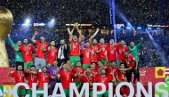 Morroco's players celebrate with the trophy after winning the FIFA Arab Cup 2025 final football match between Jordan and Morocco at the Lusail Stadium Stadium, in Lusail on December 18, 2025. (Photo by Karim JAAFAR / AFP)
